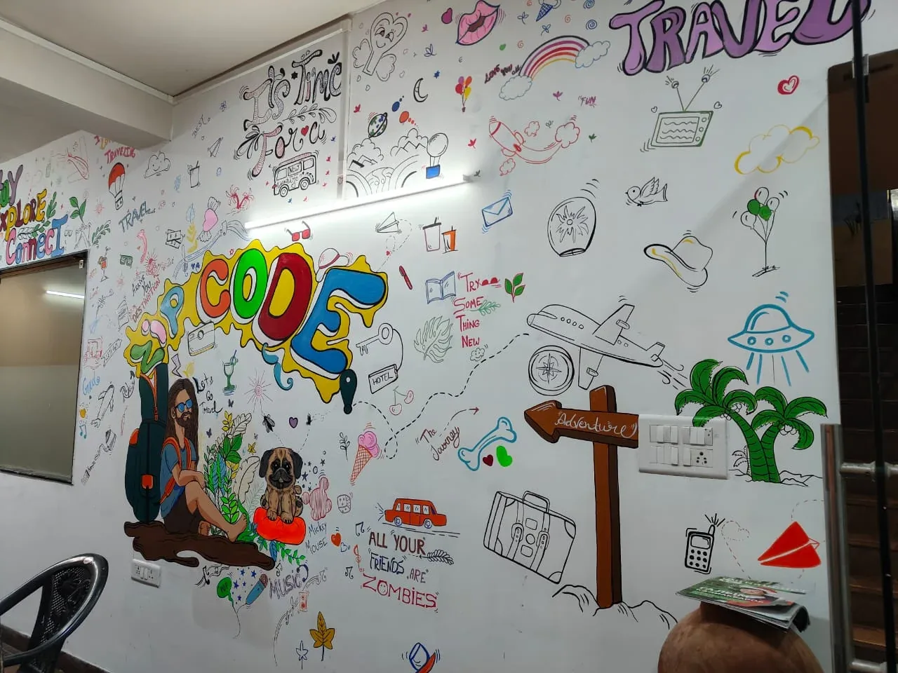 Travel-themed doodle wall with an aeroplane, luggage, plants and colourful lettering