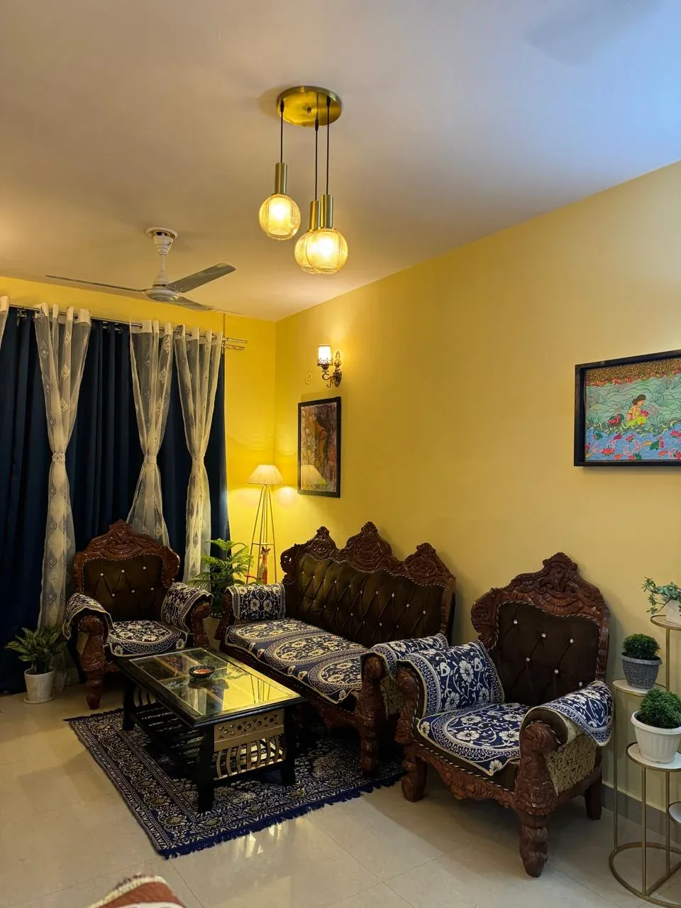 Living room with a framed folk-art painting above a carved sofa