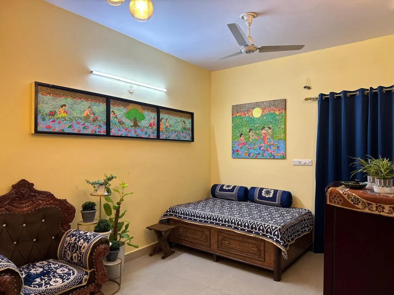 Framed folk-art series and a large nature painting in a sitting room