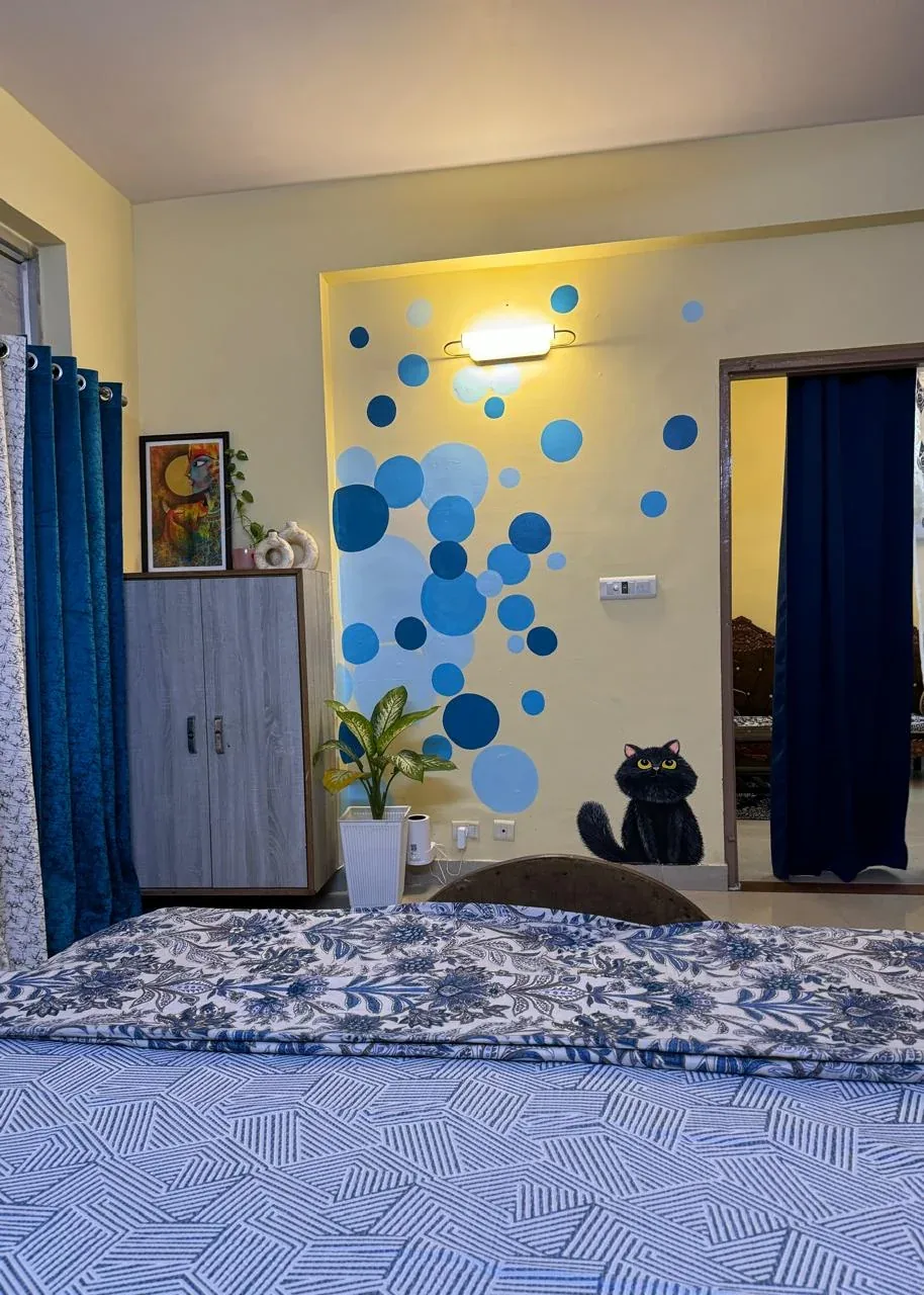 Bedroom wall painted with blue bubbles and a black cat